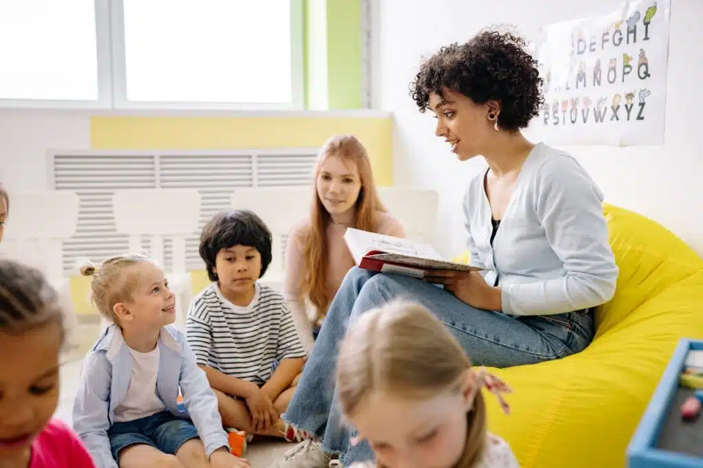 Cuentos y mitología para niños; Teacher reading to preschool kids in a colorful classroom setting. Cuentos Infantiles.